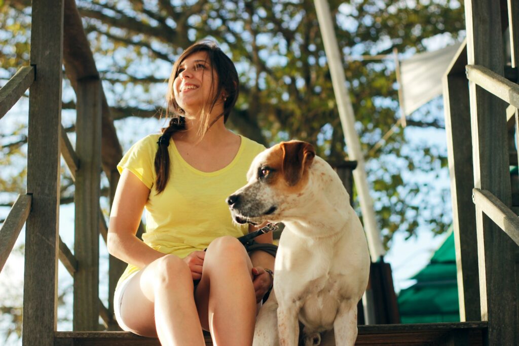 featured image for enhancing client retenetion featuring woman in yellow shirt sitting beside white and brown short coated dog