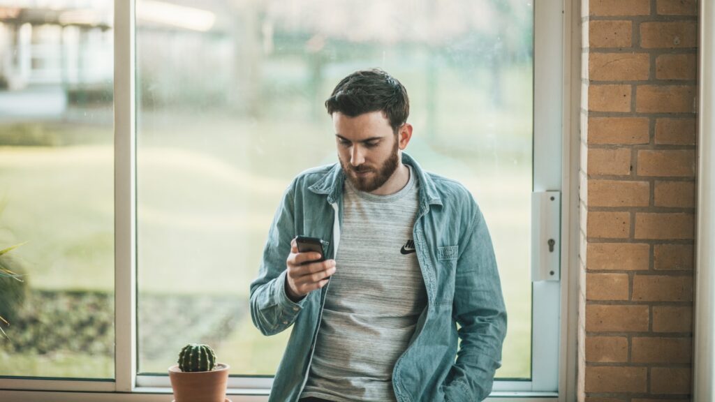 featured image of home based dog grooming featuring man using his smartphone