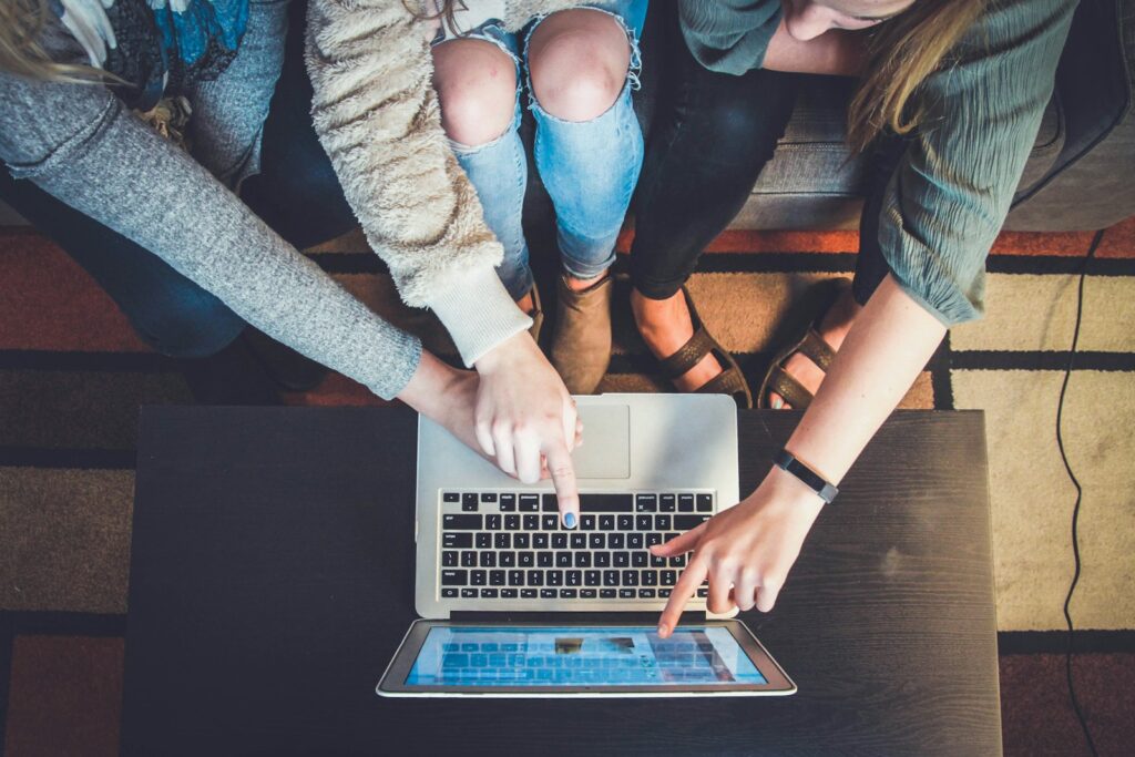 featured image for dog grooming business name ideas featuring three person pointing the silver laptop computer